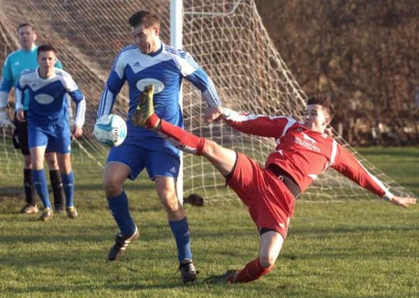 NAWN 1501101AM2 Kirk Deighton V Kirkby Malzeard. Kirkby Malzeards Sam Currie (red) and Kirk Deighton's Danny Williams (blue). (1501101AM2)