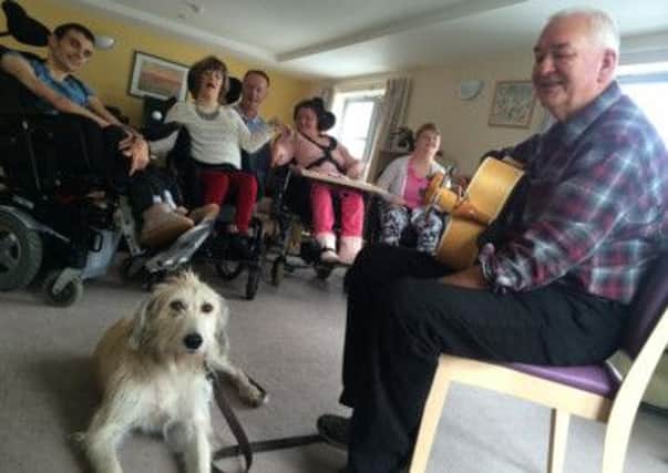 Musician Roger Busby with rescue dog Alfie at Disability Action Yorkshires Claro Road care home (s).