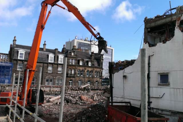 The high reach machine on the final day of demolition at the former Beales department store.