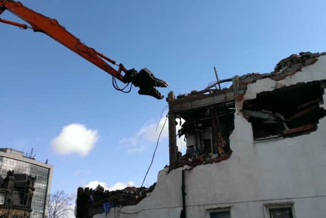 The high reach machine on the final day of demolition at the former Beales department store.