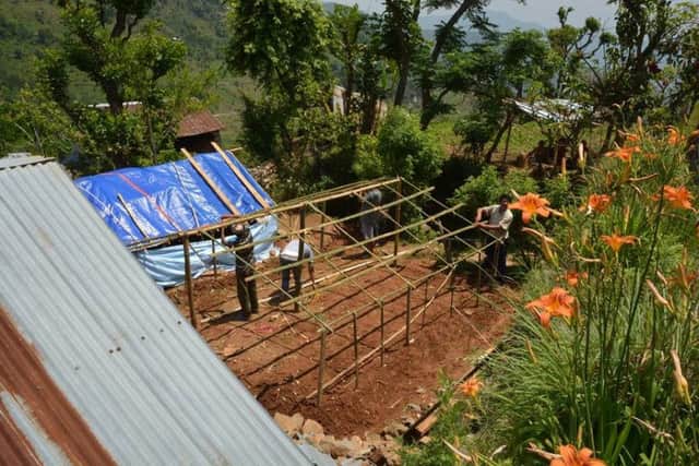 Building a shelter from bamboo and tarpaulin in Nepal. (S)