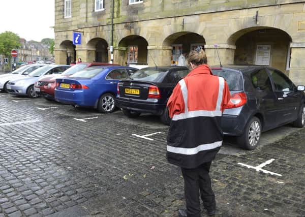 A Community Enforcement Officer checks the cars parked in Alnwick Market Place
Picture Jane Coltman