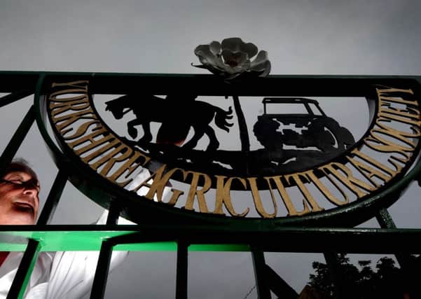 Date:14th July 2015. Picture James Hardisty, (JH1009/58a)
Great Yorkshire Show, Day 1, Steward Charles Sproull, cleans the logo of the Yorkshire Argicultulture Society on the gates on the opening day of the show.