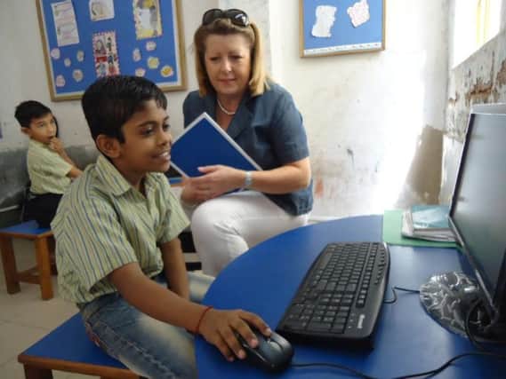 Claire Lister, managing director at Pitman Training Group, meets a boy on a visit to Katha, a charity running a school in a slum area of Delhi, where they attempt to teach basic and vocational skills. (S)