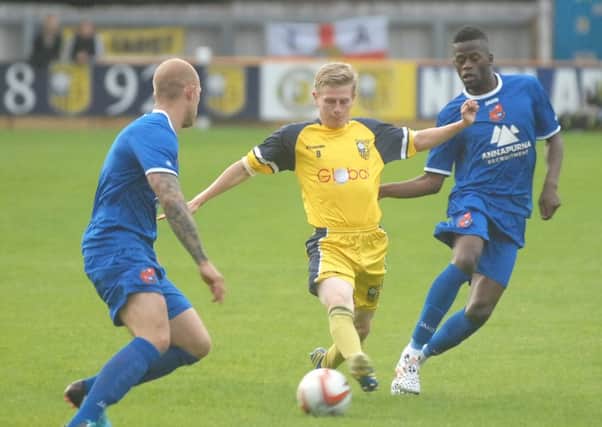 David Brown takes on Harrogate Town's Danny Ellis and Cecil Nyoni (1507285AM3)