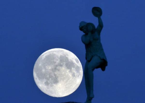 The moon rises over a statue on the Whitley Bay Dome, as the UK experiences its first 'blue moon' since 2012.