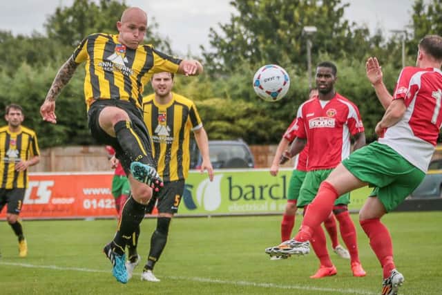 Harrogate Town's Danny Ellis smashes the ball clear (Photo: Caught Light Photography)