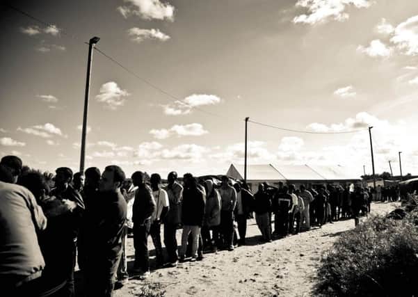 Refugees queuing for supplies at the Calais 'Jungle' camp. (Picture by Jude Palmer)