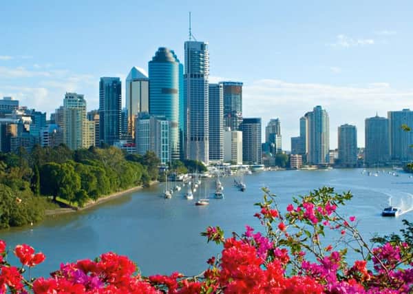 The skyscrapers of Brisbane along the Brisbane River, Queensland, with pretty blooms in the foreground. PA Photo/Tourism Queensland.