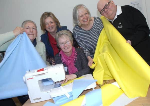 Sandra Walker (partnership  administrator) gets to work on some of the bunting watched by Jenny Booker (volunteer), Katy Penn(partnership manager), Paula Newson Smith (chair of Nidderdale Plus Partnership) and Mike Perry (vice chair of Nidderdale Plus Partnership). (1603081AM1)