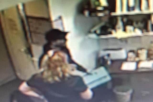 CCTV shows the burglar talking to office staff.