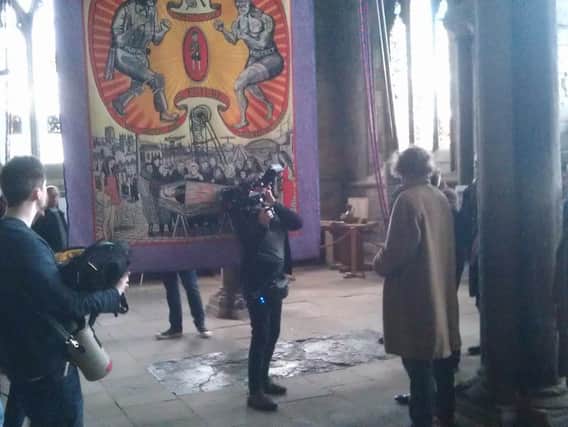 Artist Grayson Perry in the overcoat unveils his new tapestry inside Durham Catherdal before the filming with The Harrogate Band.