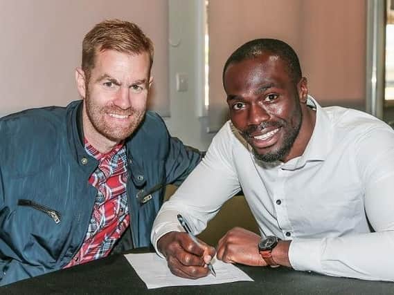 Chib Chilaka signs his contract at Harrogate Town alongside Simon Weaver (Photo: Caught Light Photography)