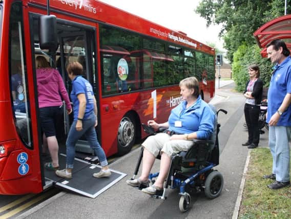 Instructors from Henshaws College in Harrogate use a wheelchair access ramp to board The Harrogate Bus Companys route 1 service.