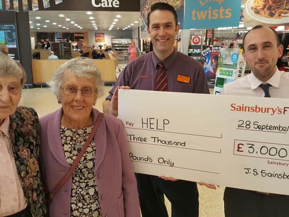 W. Kelly and E. Wilkinson receive cheque from Sainsbury's.