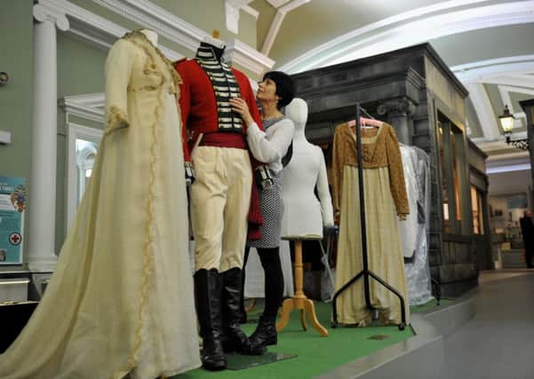 Judith Bright from Cosprop fitting Alan Rickman's bridegroom outfit alongside Kate Winslet's wedding dress from the 1995  film 'Sense and Sensibility' at the Royal Pump Room Museum in Harrogate, part of the new exhibition 'Jane Austen and Charlotte Bronte: Costumes from Films and Television' which starts Saturday unti 31 December.