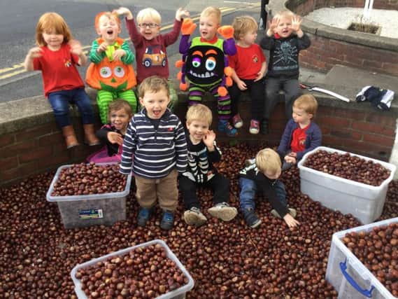 Some of the children at Oatlands Pre-School surrounded by a sea of conkers.