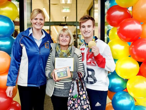 Store Manager Clare Vause and Jack Laugher with the first Customer, Jan Mitchell who queued all night to receive her prize.