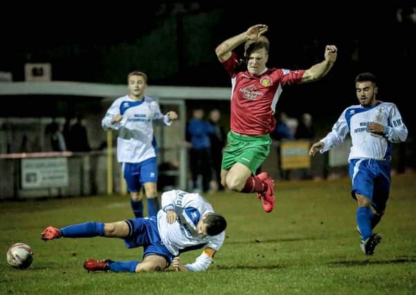 Jordan Hendrie hurdles a challenge during Harrogate Railway's defeat to Rainworth Miners Welfare in October. Picture: Caught Light Photography