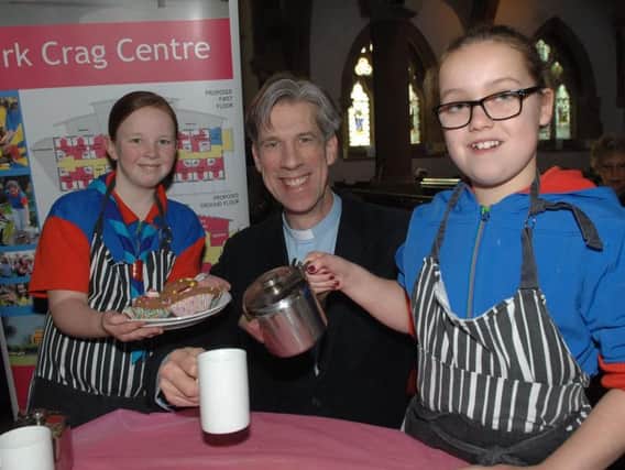 Guiders Hettie (10) and Chloe (11) serve the Rev. Alan Garrow during the guides fundraising morning at St. Peter's Church. (1702181AM1).