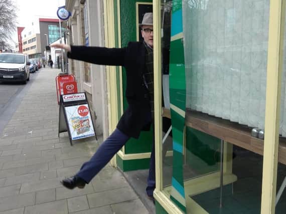 Doing a Harry Worth...Jack Land Noble performing the 'miraculous levitation' in a Barnsley shop window.