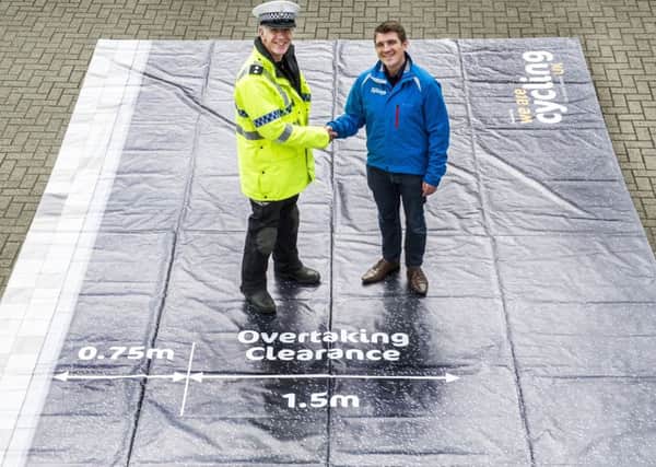 Inspector Dave Barf of North Yorkshire Police and David Murray from Cycling UK with the safe pass mat, showing the distance vehicles ought to be leaving.