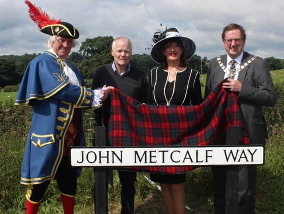 Roger Hewitt, the Town Crier of Knaresborough;  Bernard Higgins of the Blind Jack of Knaresborough Tri-centennial Anniversary Committee; Coun Anne Jones, Mayor of the Borough of Harrogate; and Coun David Goode, Mayor of Knaresborough unveil the road sign in honour of John Metcalf.