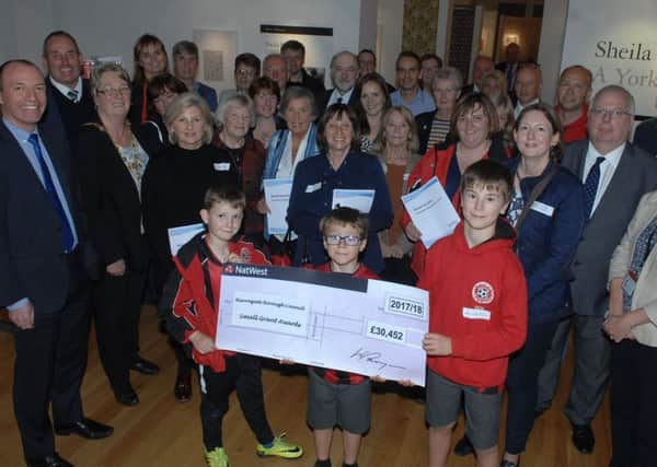 Three members of the Scotton Scorchers Junior Football Club Freddie Robinson (8), Alex Margason(7) and his brother Ben(9) hold the Â£30,453  cheque  that was awarded to thirteen groups from around the area by the Harrogate Borough Council's Small Grants Fund.