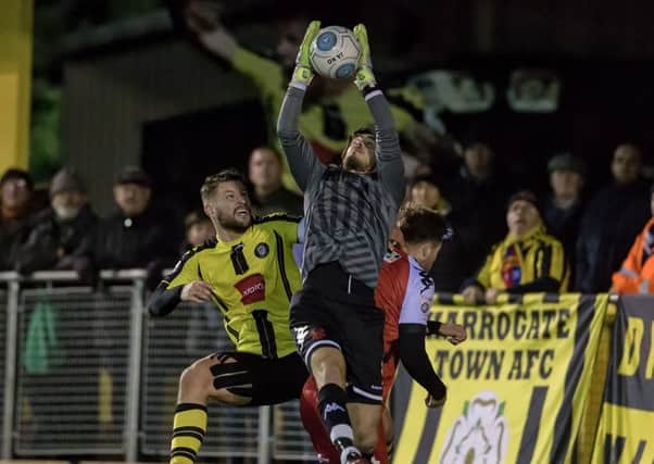 Simon Ainge challenges Kidderminster goalkeeper Brandon Hall during Tuesday night's 2-2 draw at the CNG Stadium. Picture: Caught Light Photography