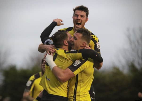 Simon AInge, left, is mobbed by Ben Middleton and Joe Leesley after netting his side's second goal against AFC Telford United. Picture: Town Pix