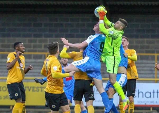 Harrogate Town striker Mark Beck is beaten to the ball by Boston United goalkeeper George Willis. Picture: Town Pix